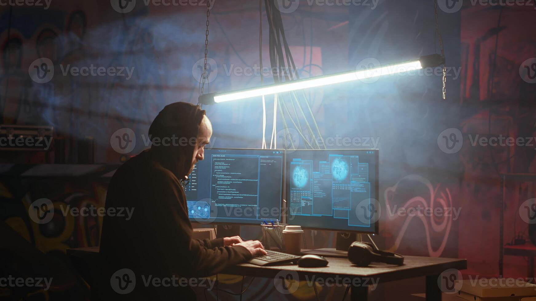Hacker in foggy neon illuminated basement with graffiti drawings on walls using advanced technology computer, running code. Cybercriminal using dark underground warehouse as crime haven, camera B photo