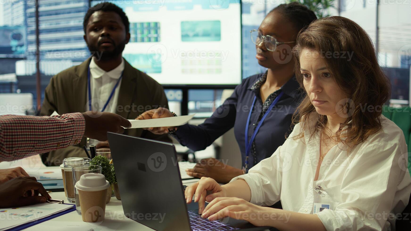 Project leader and her staff conducting a market research for progress plans, learning the trends. Forecast affiliates working on infrastructure investments to fulfill objectives. Camera B. photo