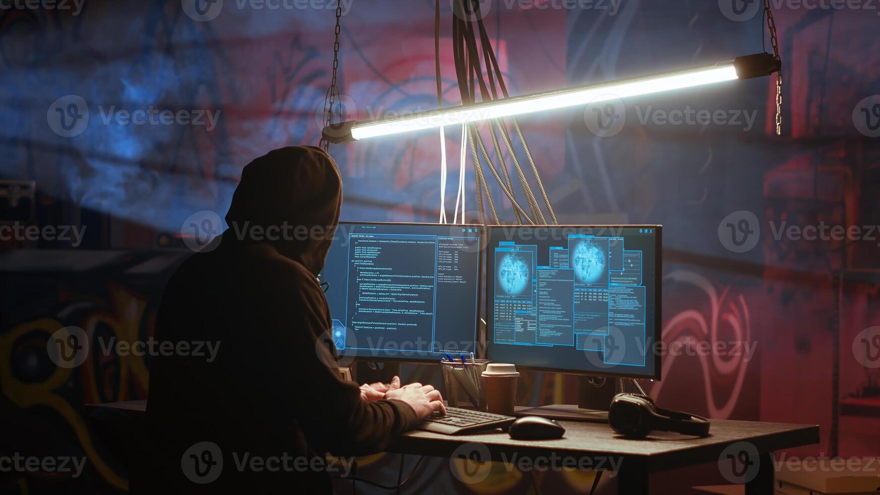 Hacker arrives in messy base of operations with neon lights and graffiti drawings sprayed on walls. Cybercriminal using ghetto hideout as HQ to commit illegal activities using computer, camera B photo