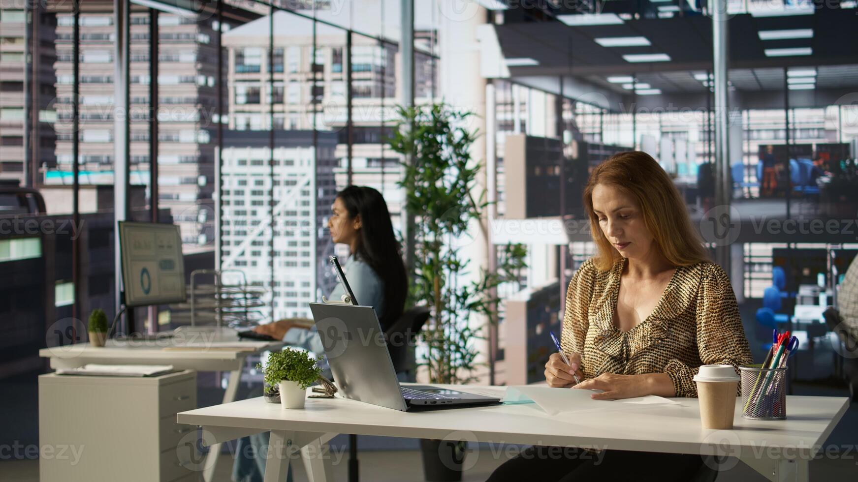 Female CEO engaging in project management using tech tools to set goals and objectives, solve problems and track the performance metrics of the company. Administrative tasks and decisions. Camera B. photo