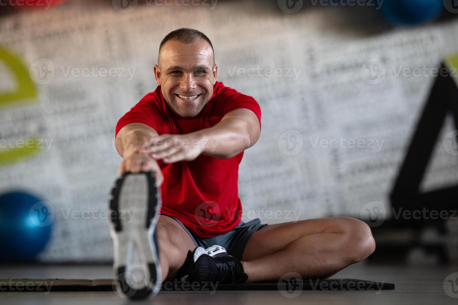 A fitness man stretches in the gym after an intense workout, focusing on recovery and flexibility. photo