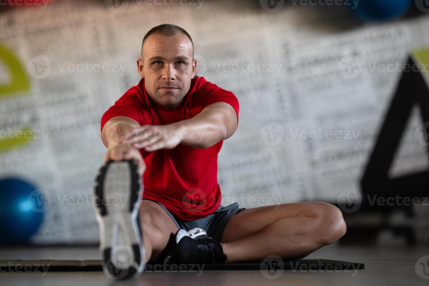 A fitness man stretches in the gym after an intense workout, focusing on recovery and flexibility. photo