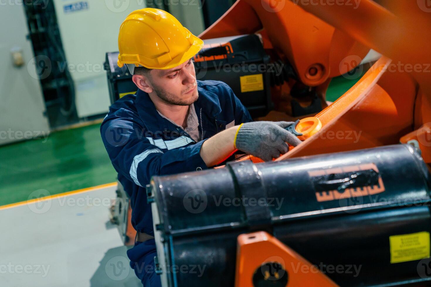 Worker performs maintenance on machinery in a factory, ensuring equipment operates efficiently and safely in an industrial setting photo