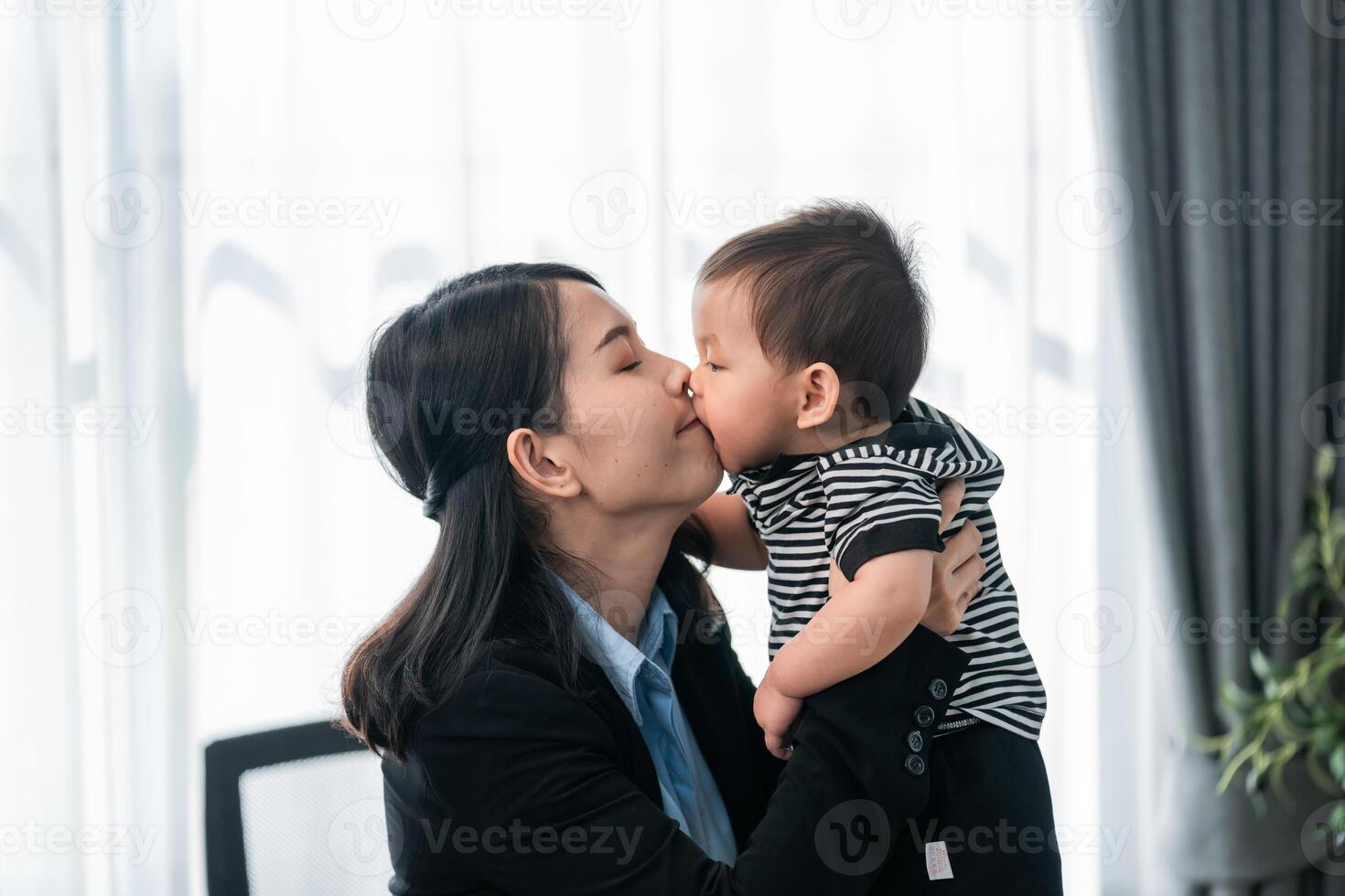 Mother and child sharing a sweet moment of affection in a modern indoor setting photo
