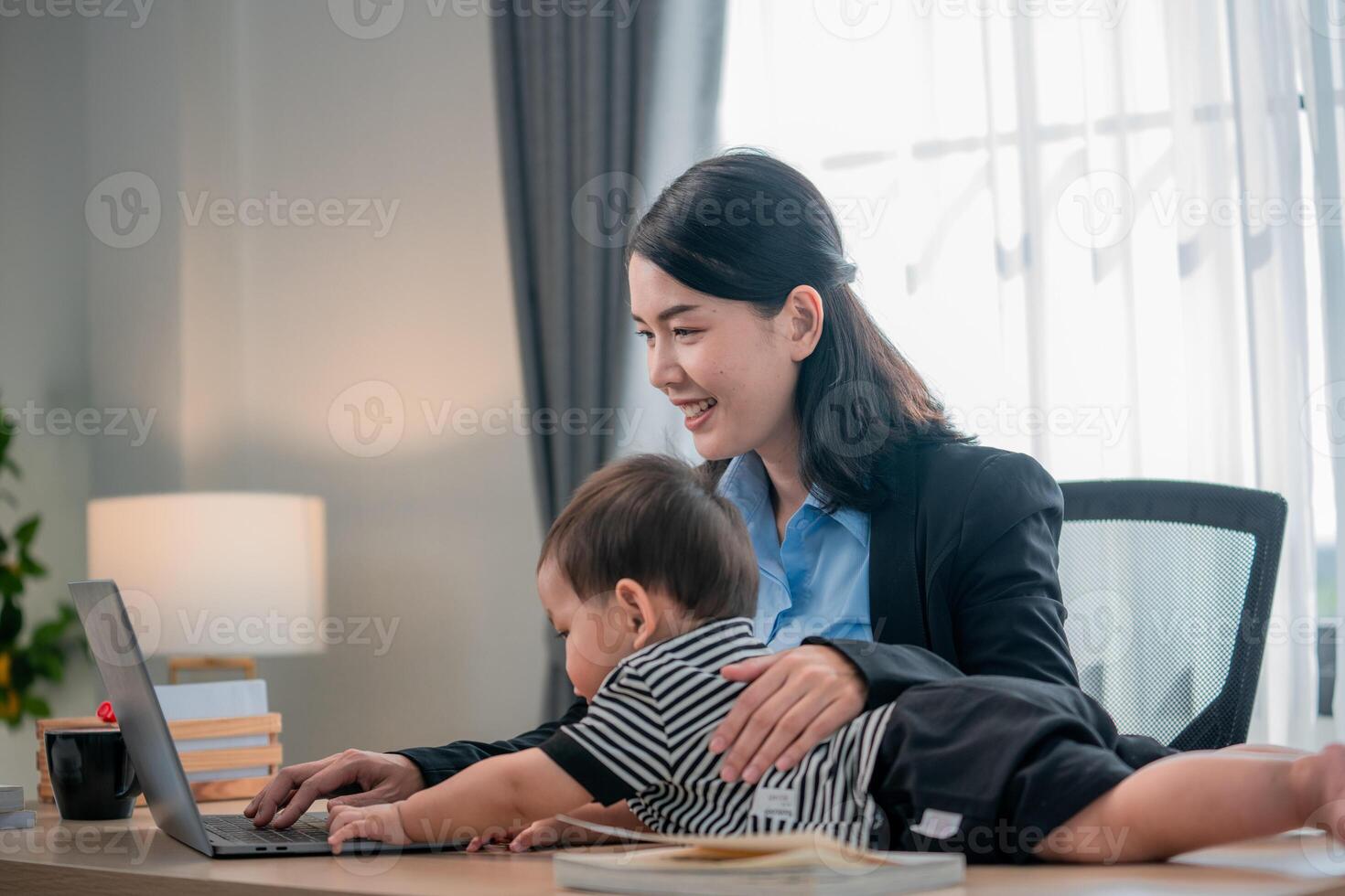 Mother working from home with child playing on her lap in a cozy office setting photo