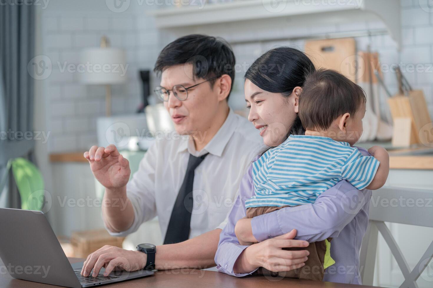 Parents engaged in remote work while caring for their toddler in a bright, modern home office space photo