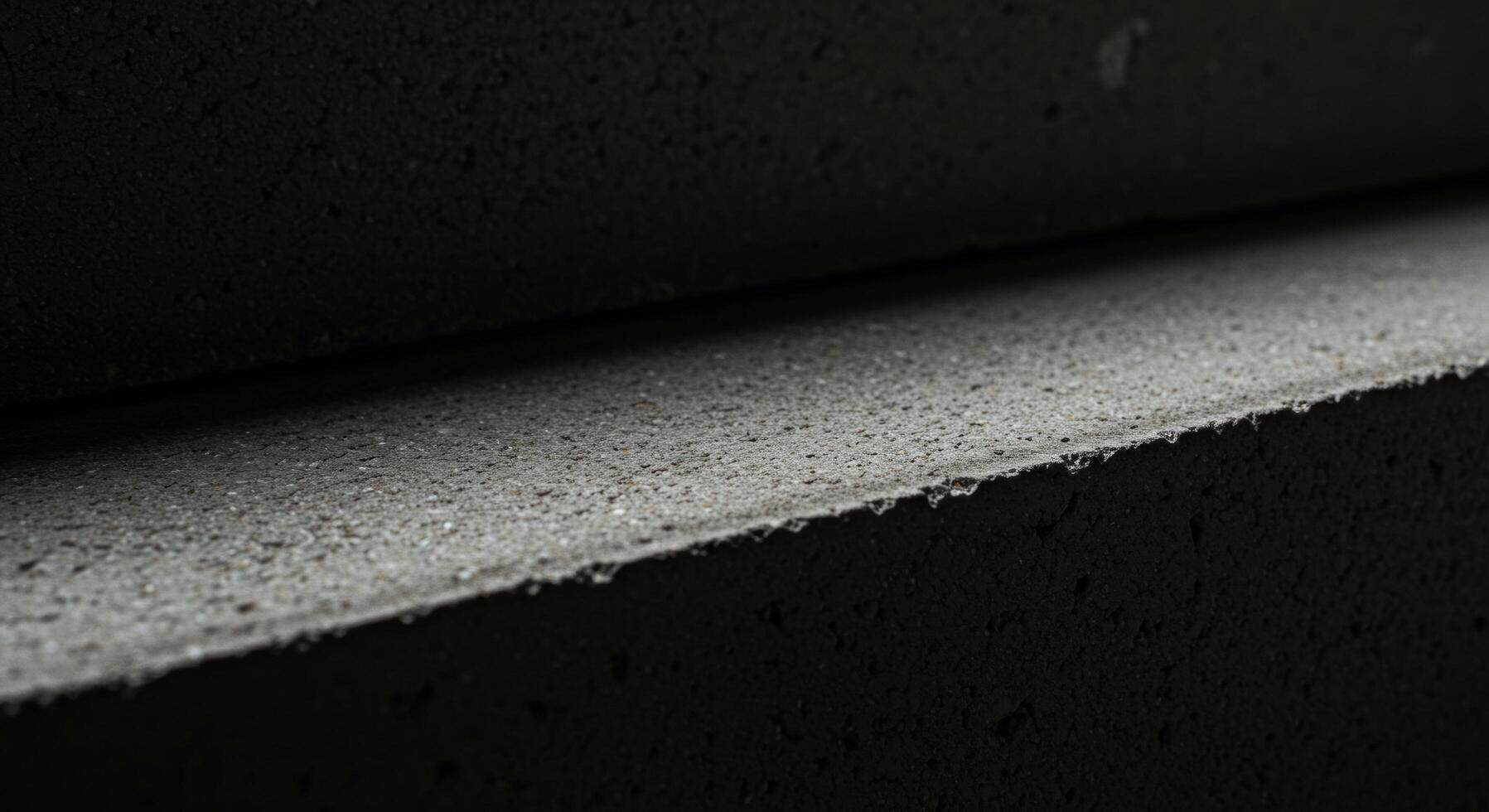 Abstract Closeup of Dark Grey Textured Blocks Stacked Horizontally Showing Subtle Light and Shadow Play photo