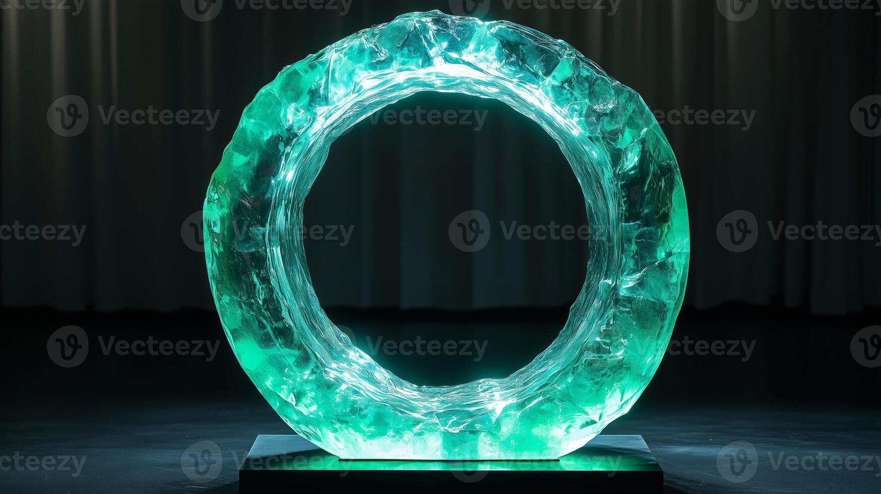 A large, circular, glowing teal glass sculpture with green lights inside, centered on a black background. 8 photo