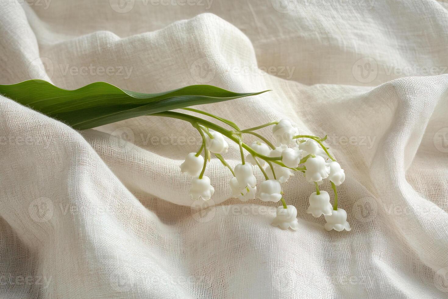 close-up delicate sprig lily of the valley flowers on a light beige linen textile, with subtle folds photo