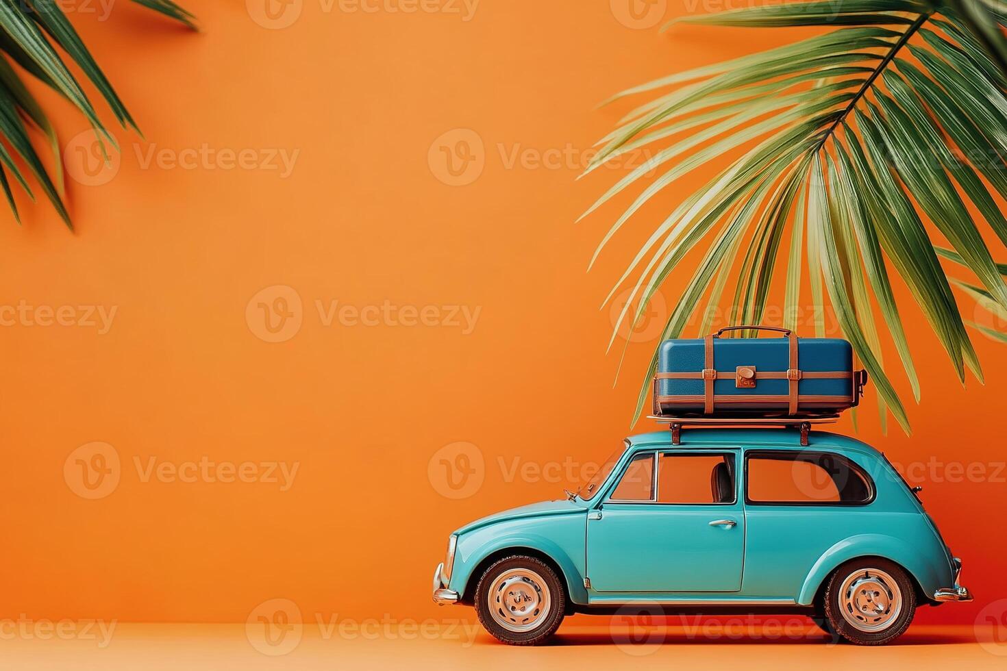 close-up little blue retro toy car with luggage surrounded by green palm leaves on orange background with copy space summer vacation traveling concept photo