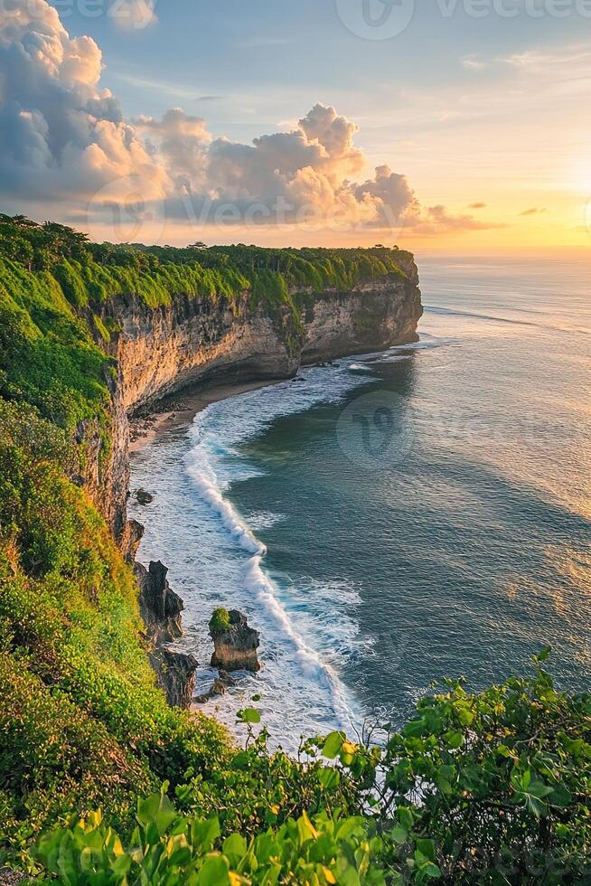 vertical image serene coastal cliffs with soft waves crashing on the shore surrounded by vibrant greenery in warm afternoon sunlight photo