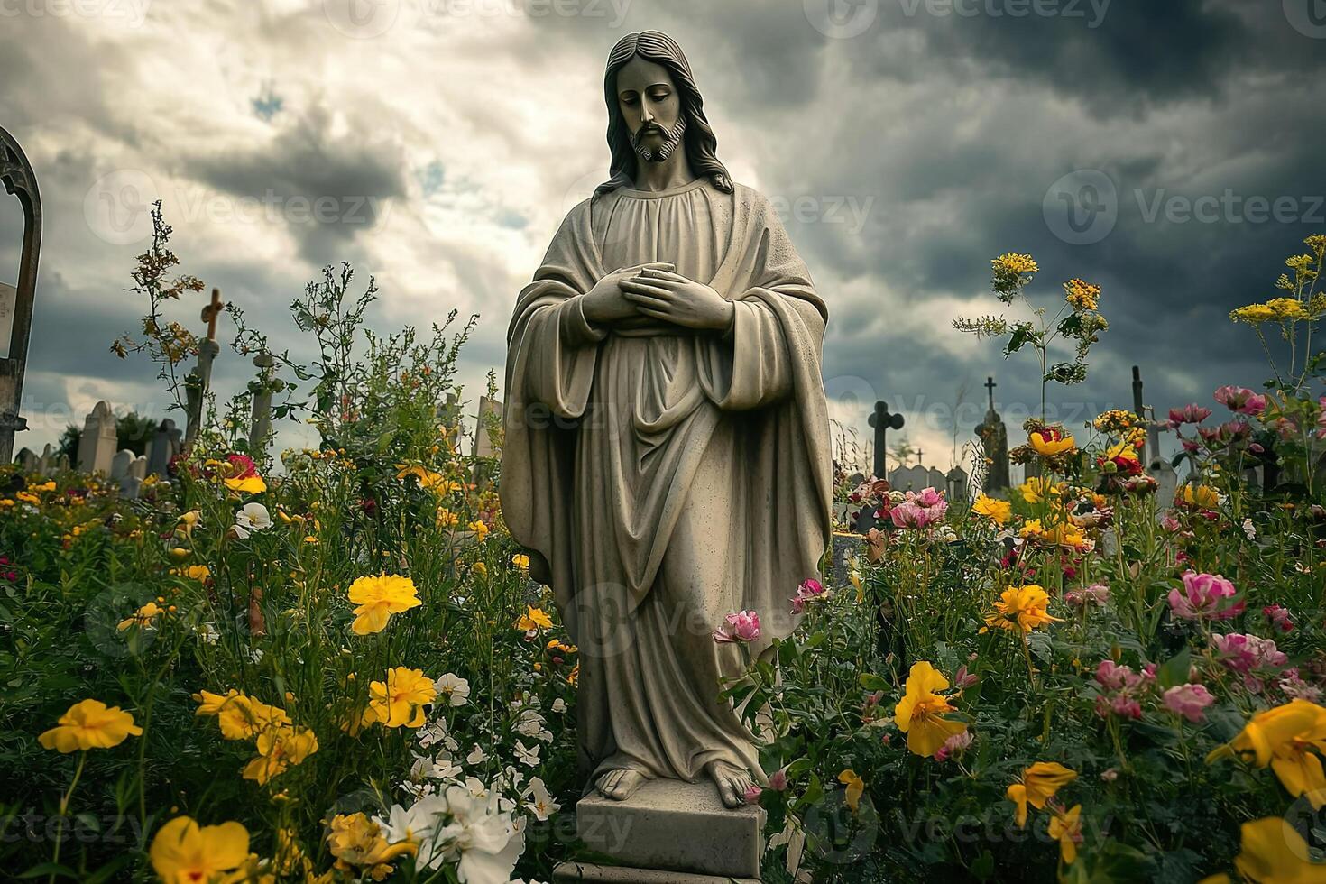 Jesus Christ statue surrounded by flowers in a cemetery, against a dramatic sky photo