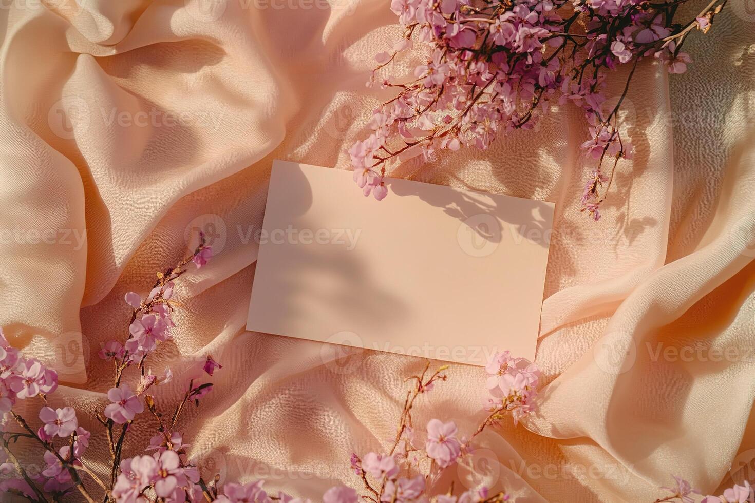 mockup top view blank empty white card surrounded by delicate lilac flowers on soft fabric background photo