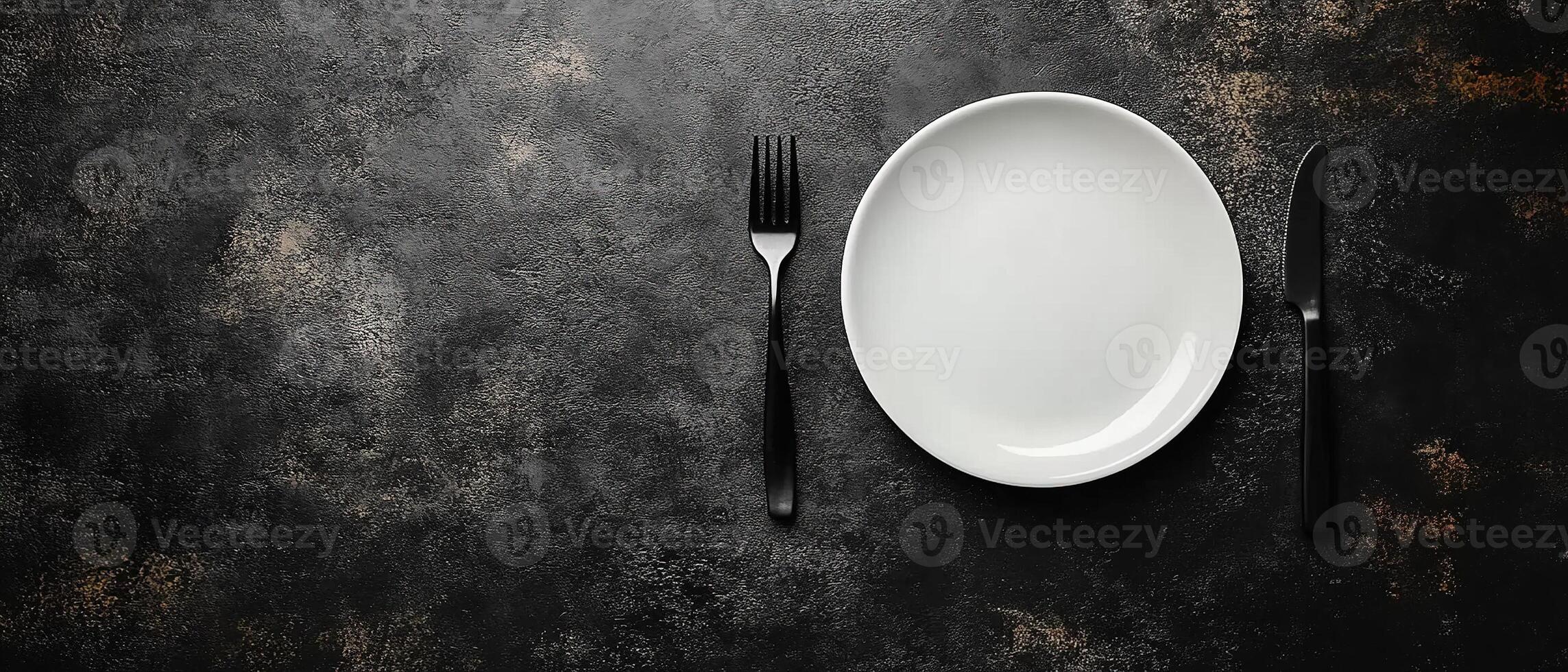 Top View of a Modern Black and White Dinner Setup Featuring a Simple Plate and Matte Black Fork and Knife with Copy Space photo