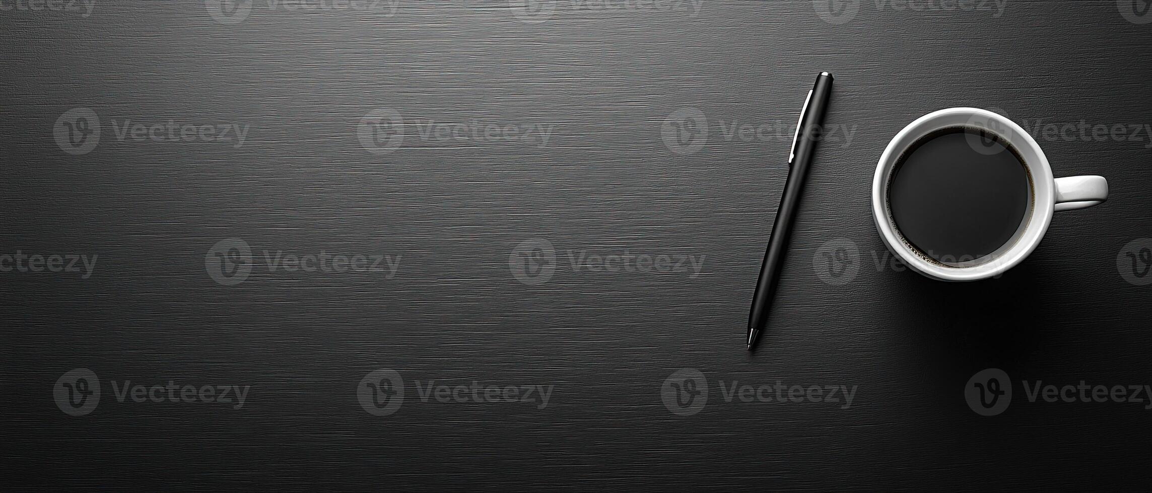 Top-Down View of a Coffee Cup and Pen on a Dark Wooden Desk with Copy Space photo