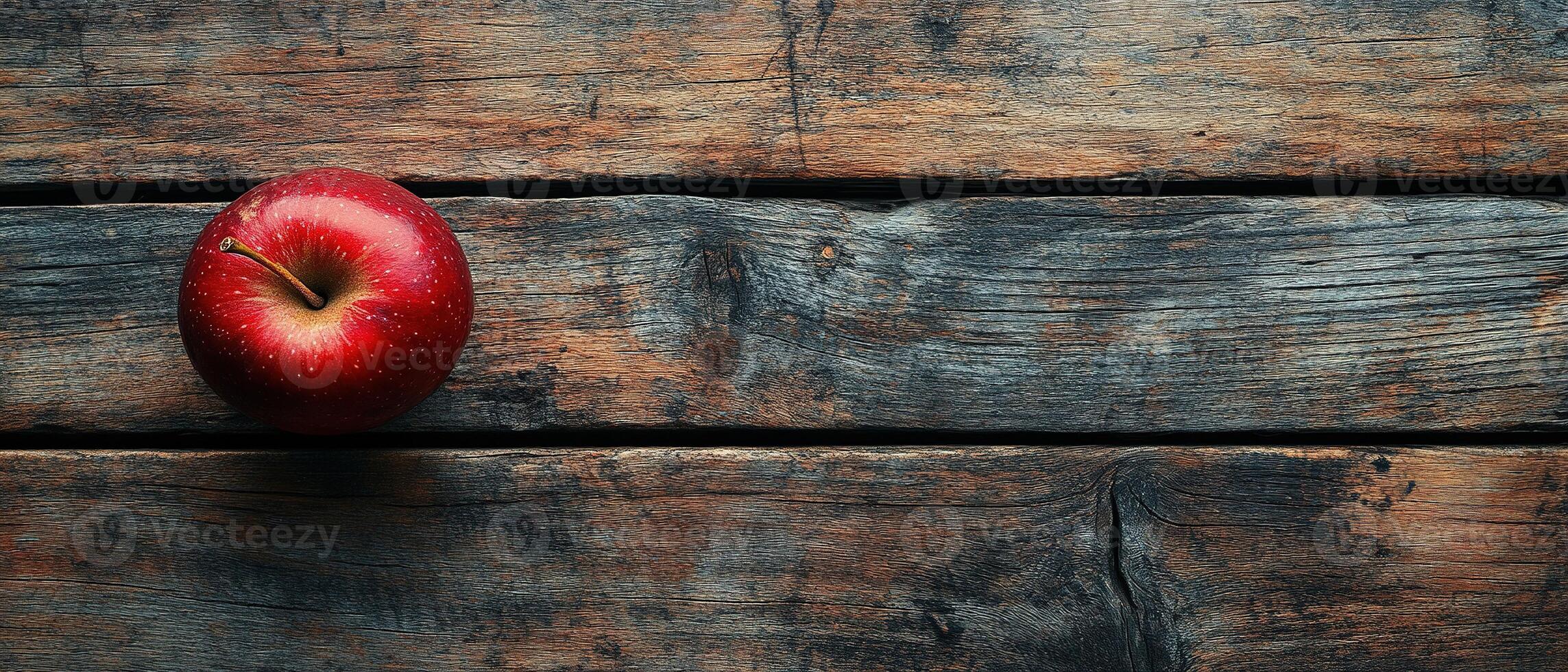 Fresh Red Apple on Rustic Wooden Table with Weathered Texture and Natural Light photo