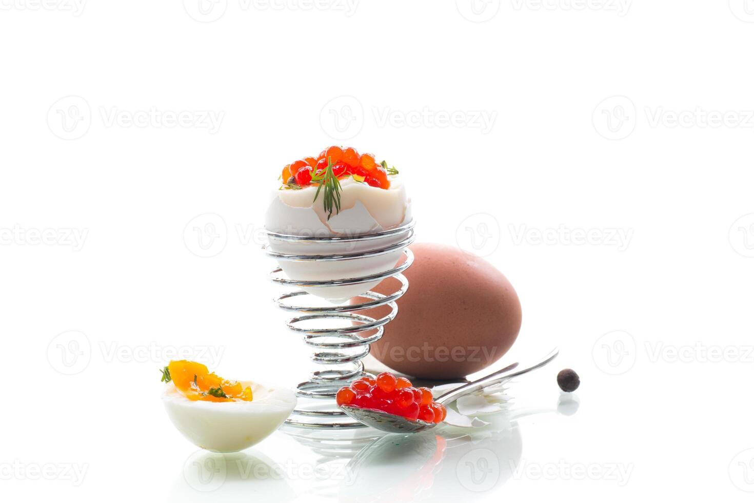 Delicacy with red caviar and boiled egg, isolated on white background photo