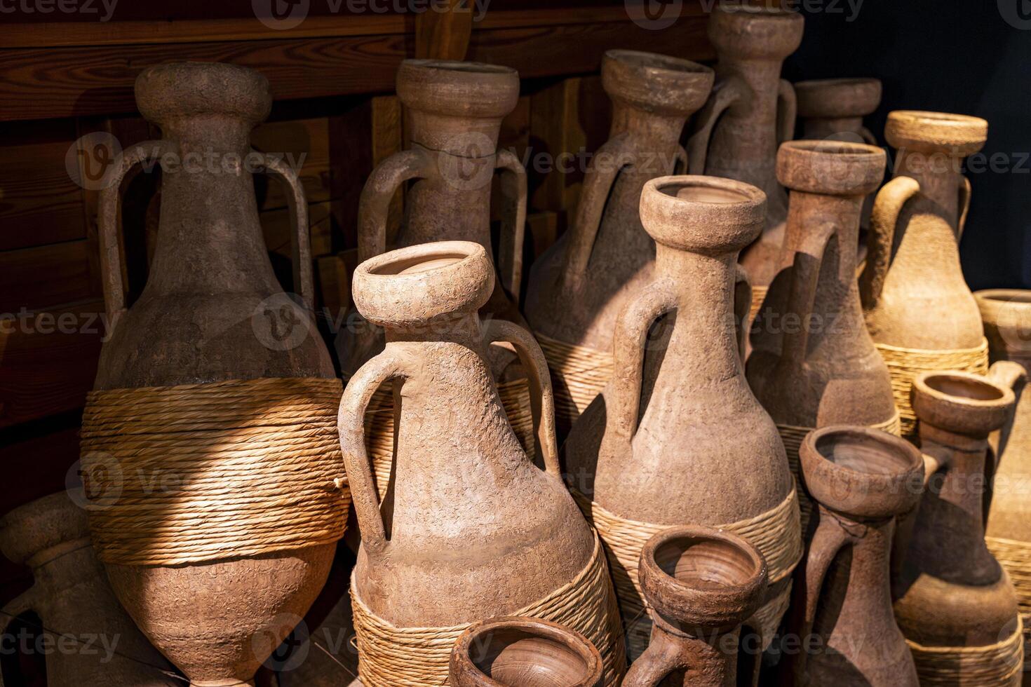 Ancient Etruscan Amphorae with Rope Wrapping in Rustic Museum Display photo