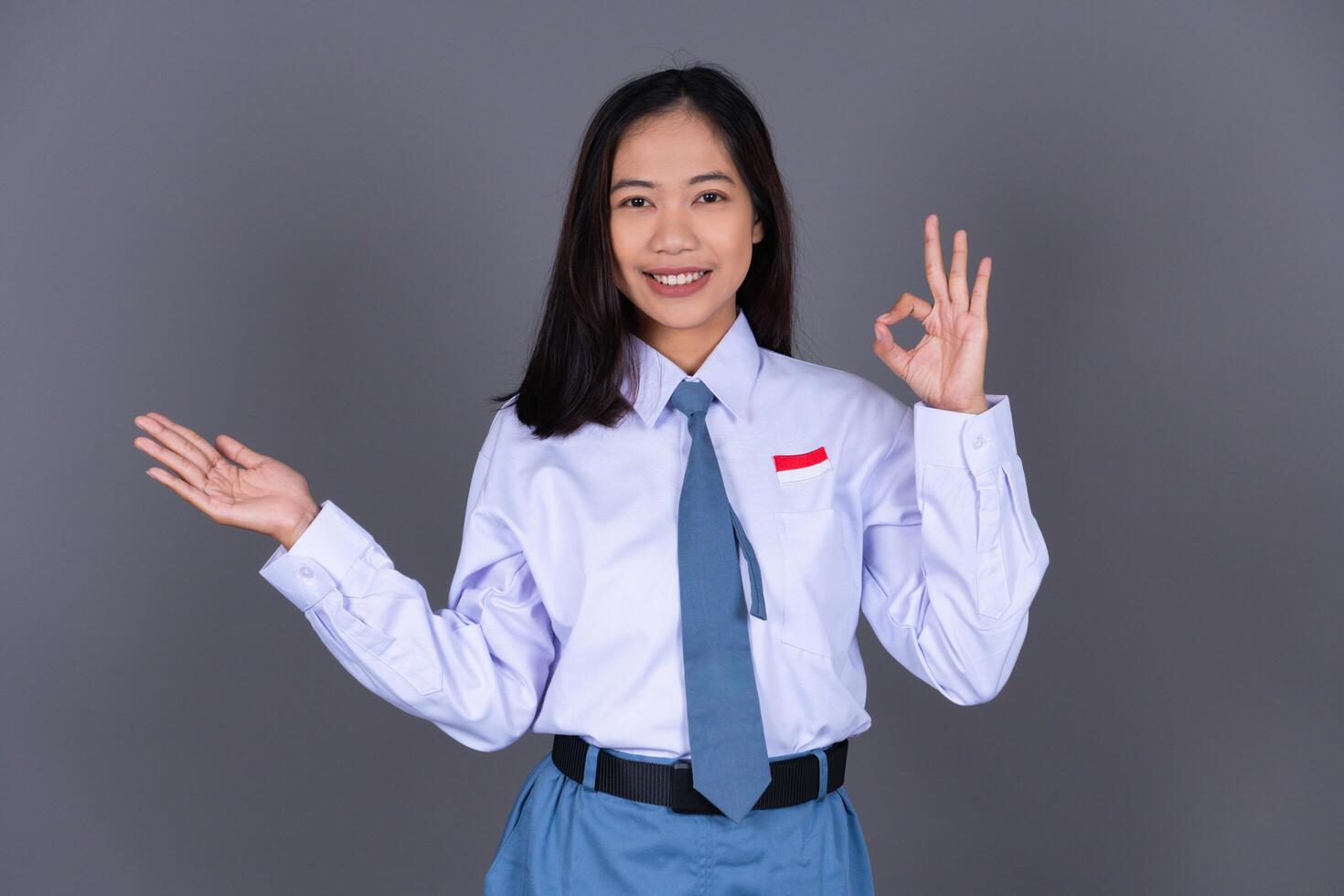 Indonesian Girl High School Student in Uniform Presenting Gesture Background photo