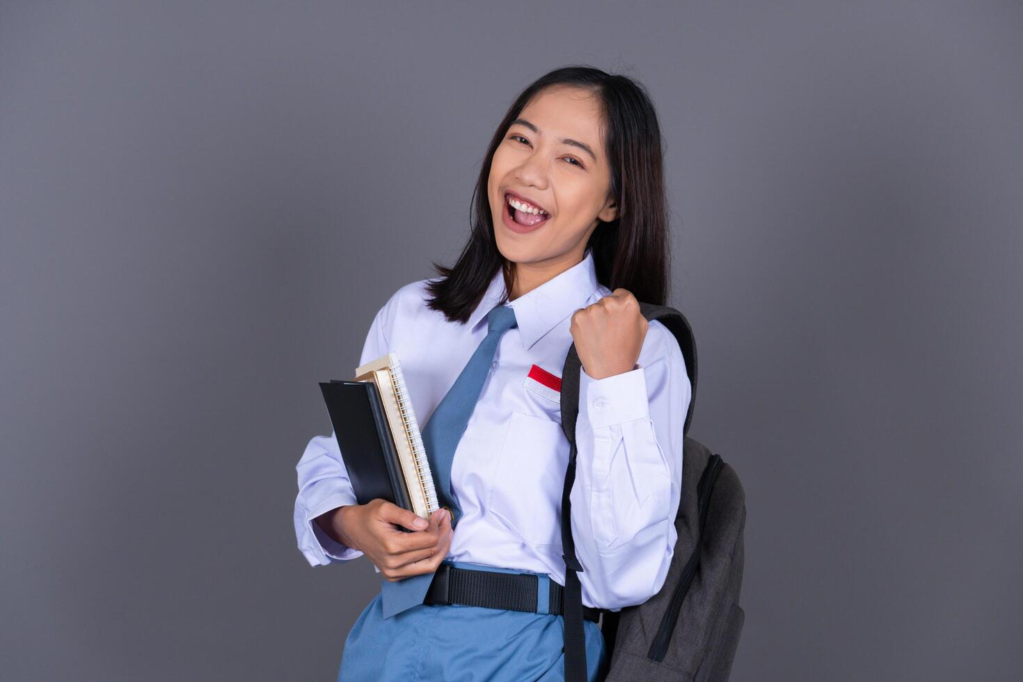 Indonesian Female High School Student in Uniform Gesture Celebrating Isolated Background photo