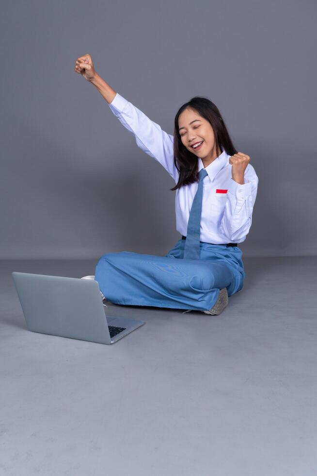 Full Body of Indonesian Female High School Students in Uniform Sitting in Floor Isolated Background photo