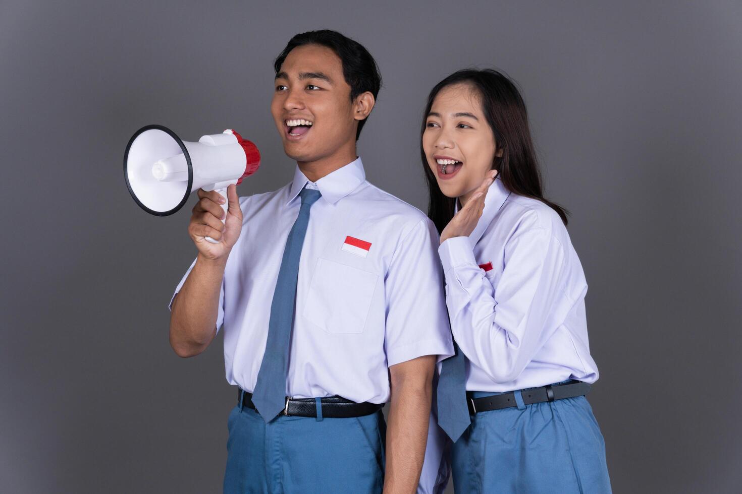 Indonesian Male and Female High School Students in Uniform with Megaphone Isolated Background photo