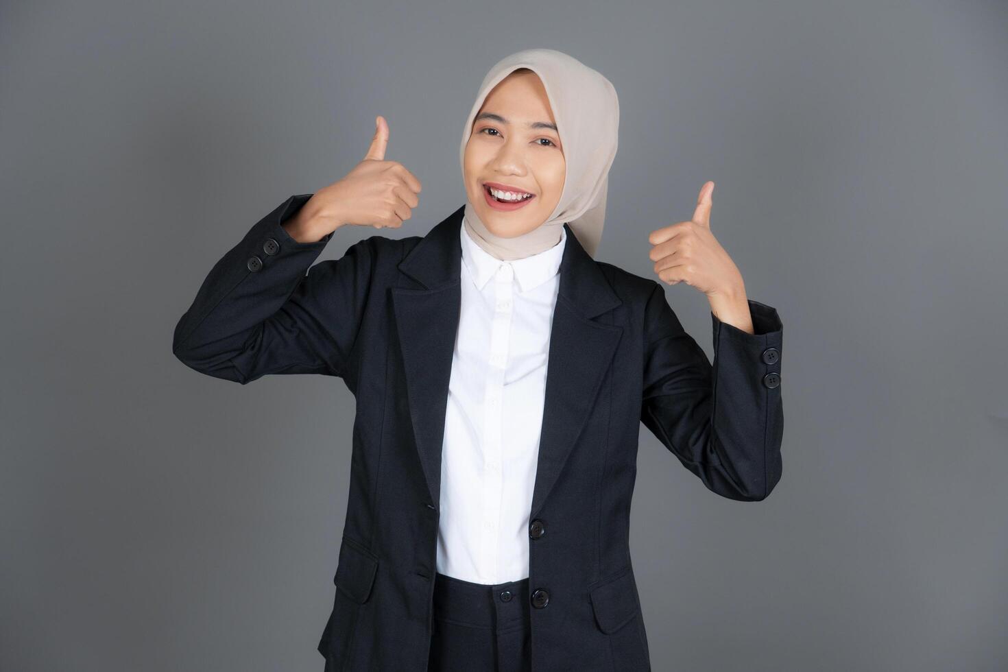 Portrait of Young Confident Female in a Hijab Thumbs Up in Approval or Recommendation Background photo