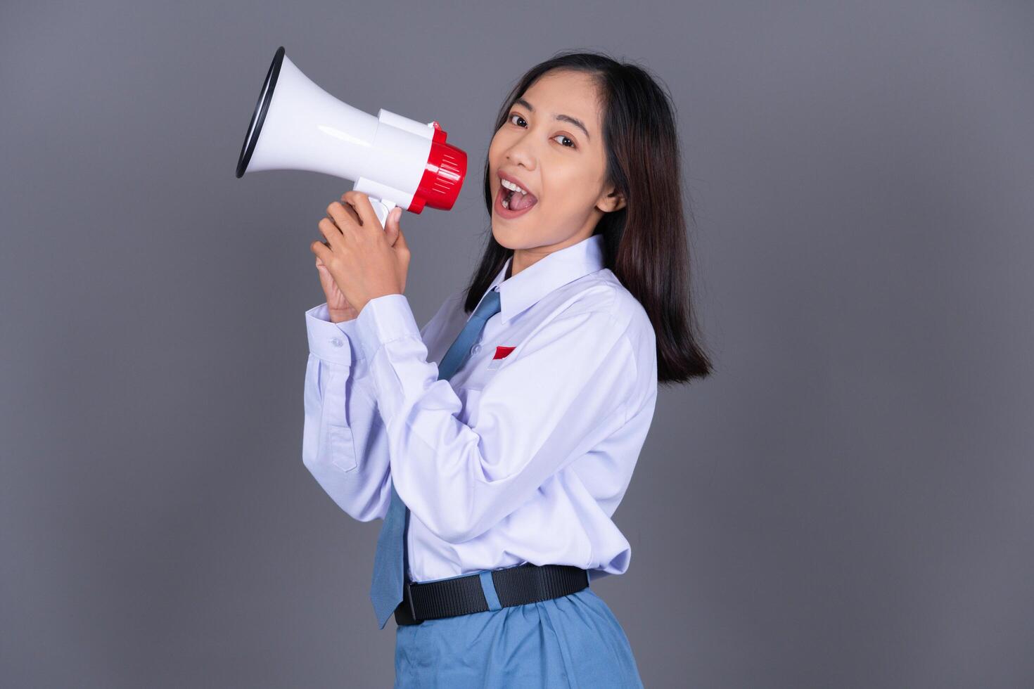 Indonesian Girl High School Students in Uniform with Megaphone Isolated Background photo