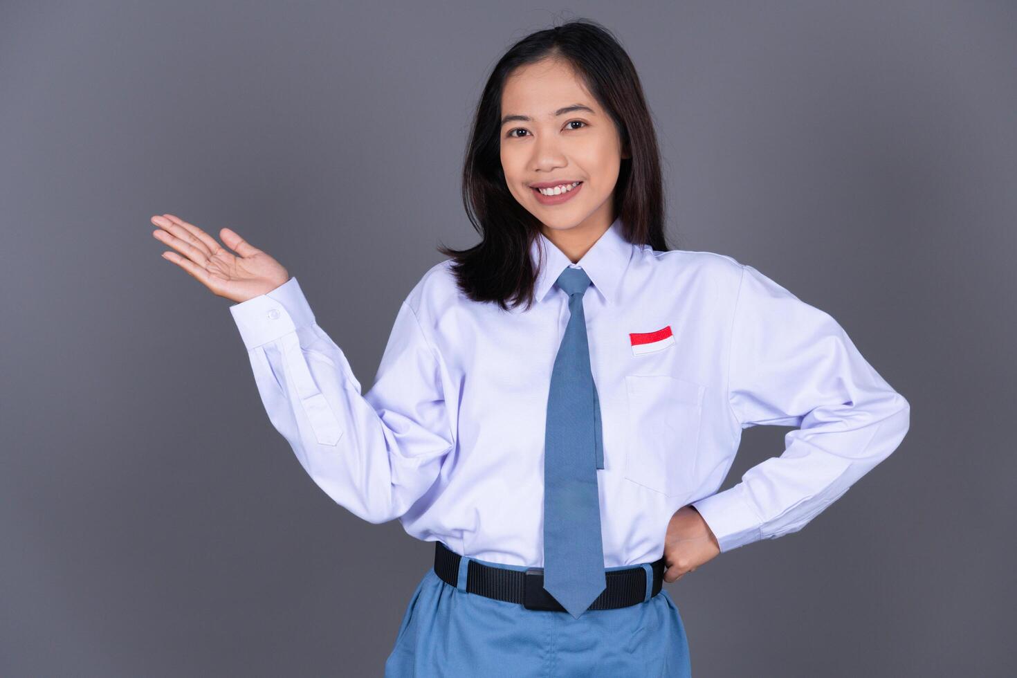 Indonesian Female High School Student in Uniform Presenting Gesture Background photo