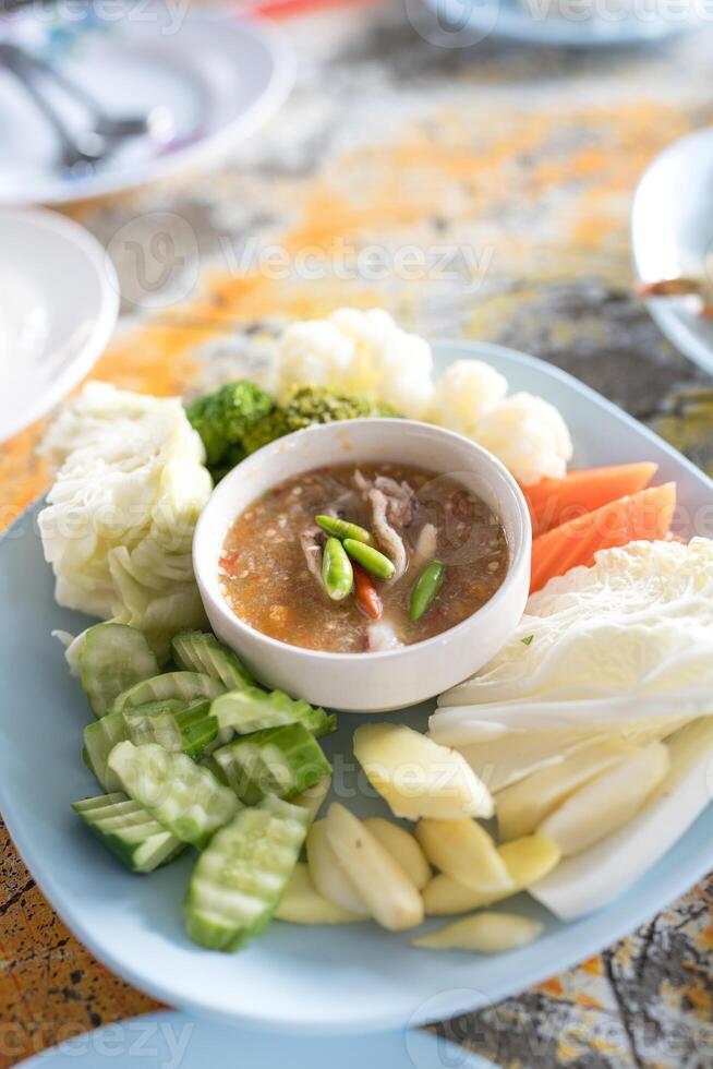 Spicy crab roe chili paste with fresh and raw vegetable and herb. photo