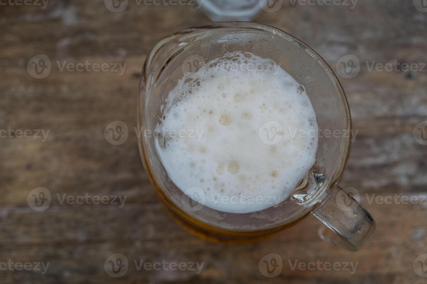 Glass of beer with foam is standing photo