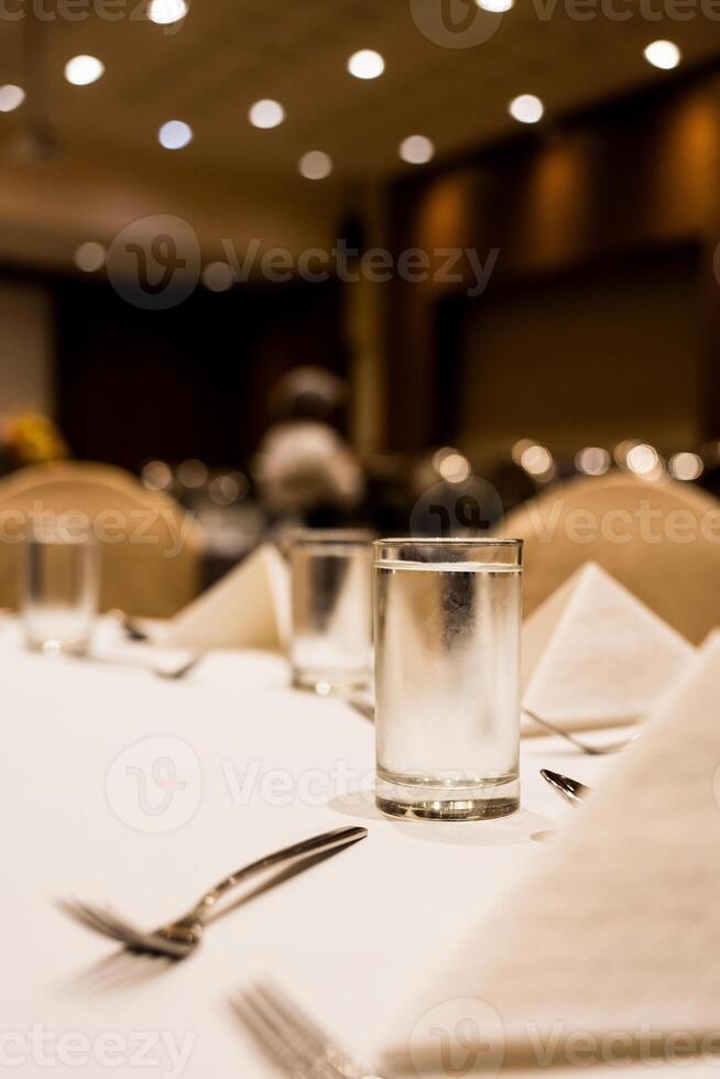 Glass of cool water on the table setting in the event at hotel photo