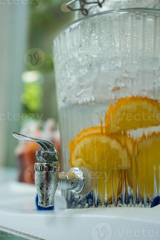Refreshing cool water with orange slice at the bar in jars with tap photo