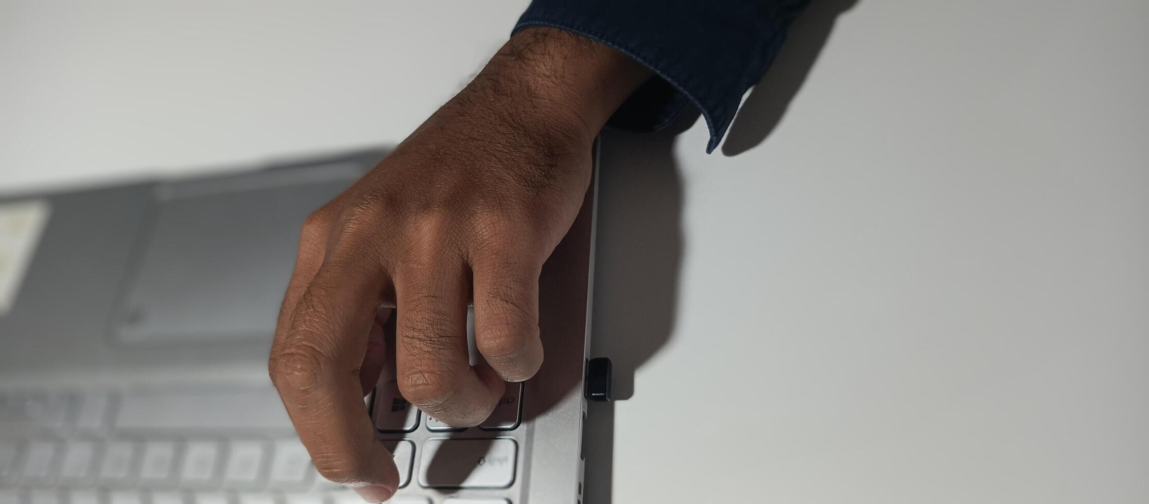 A person's hands are typing on a laptop keyboard photo
