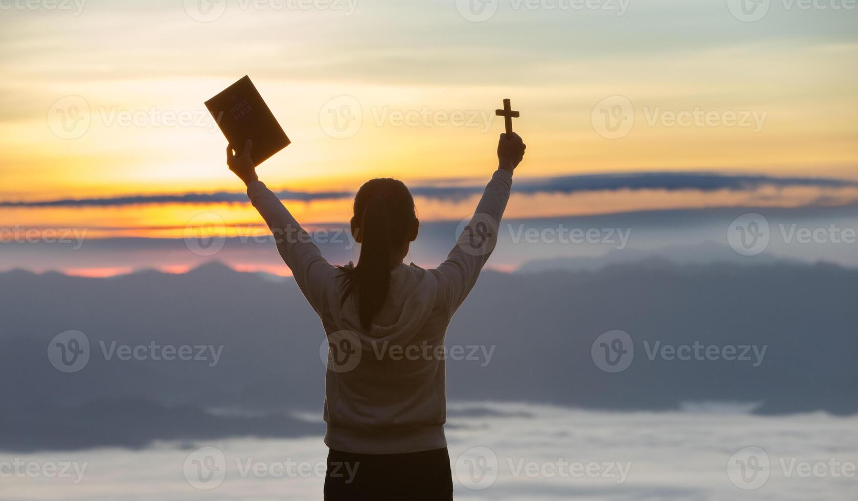 Women standing holding holy bible for worshipping God at sunset background, Pray to the god,. photo