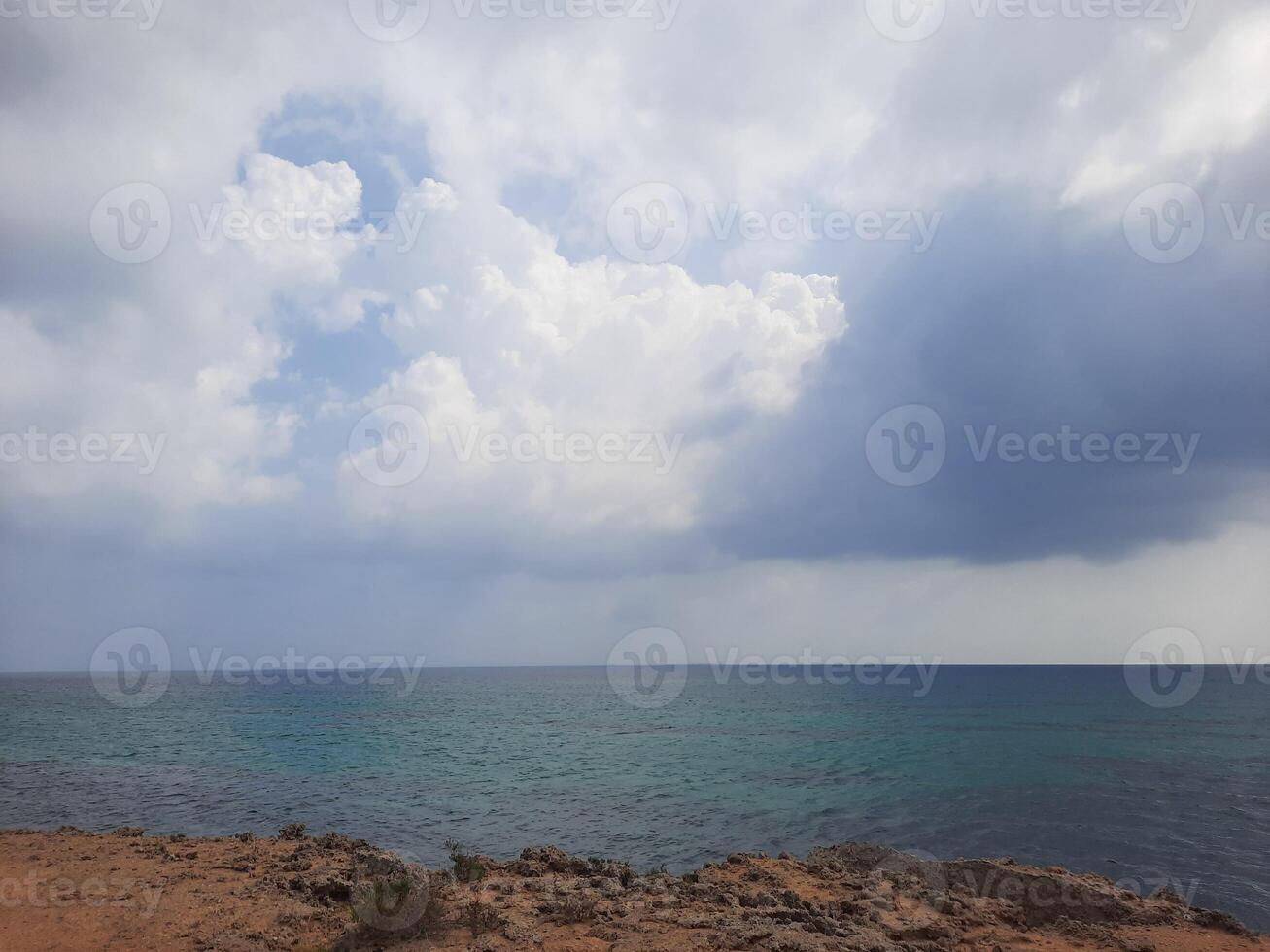 Al Farasan Islands in Jazan, Saudi Arabia are stunning at daytime due to the beautiful scene created by the deep blue water, rocky formations, and dark clouds. photo