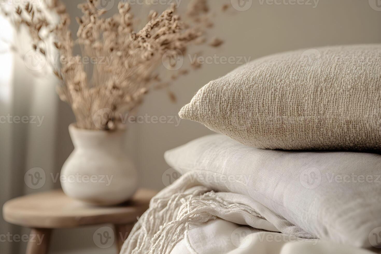A stack of pillows and a vase on a bed photo