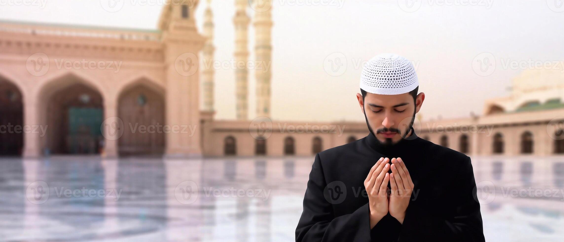 Faithful Muslim in black thobe praying with raised palms. Ramadan and Islamic worship photo