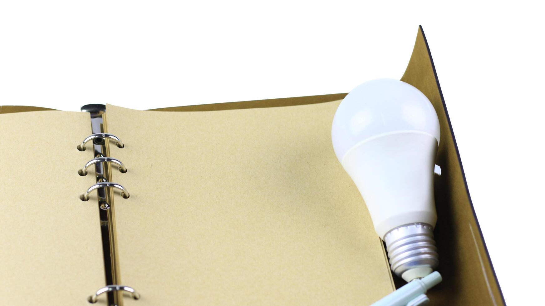 White light bulb on an open notebook, symbolizing creativity, innovation, inspiration and new ideas. photo