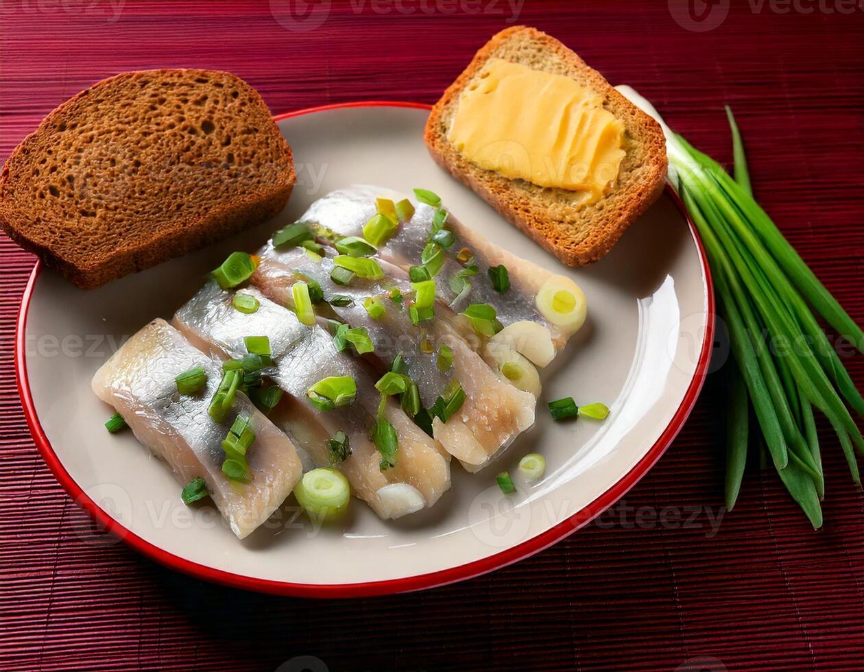 Salted herring slices with onion rings and parsley on white plate on dark grey background photo