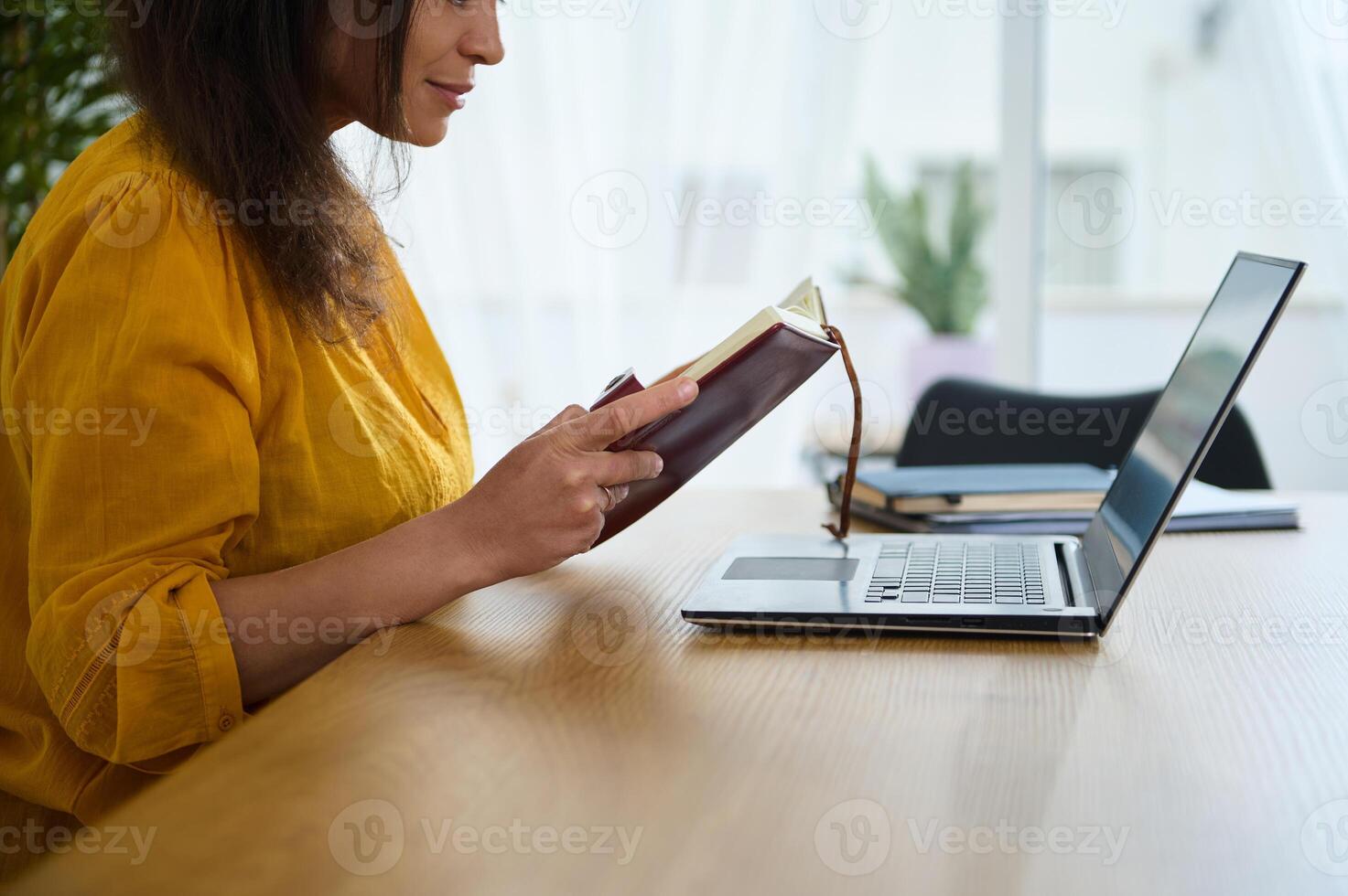 Young Businesswoman Working Remotely in Home Office with Laptop and Notes photo