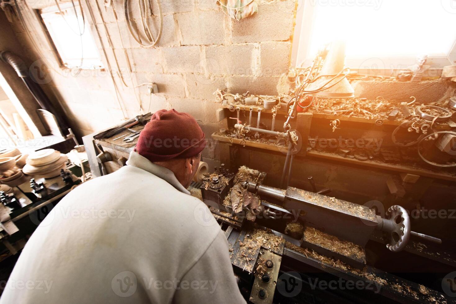 Elderly Craftsman Working in a Rustic Workshop photo