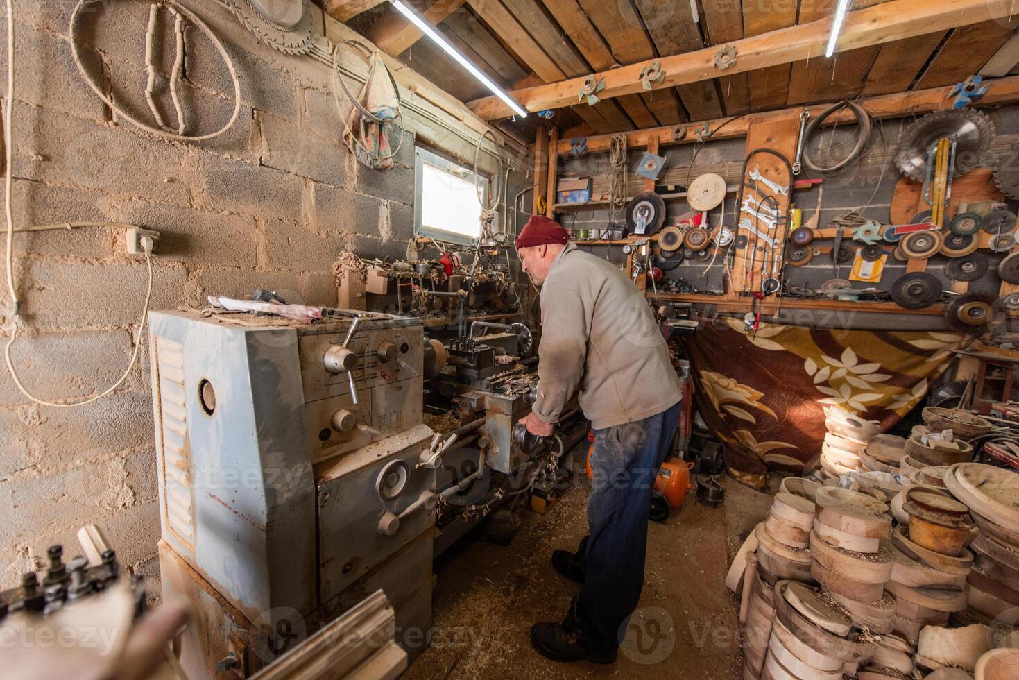 Elderly Craftsman Working in a Rustic Workshop photo