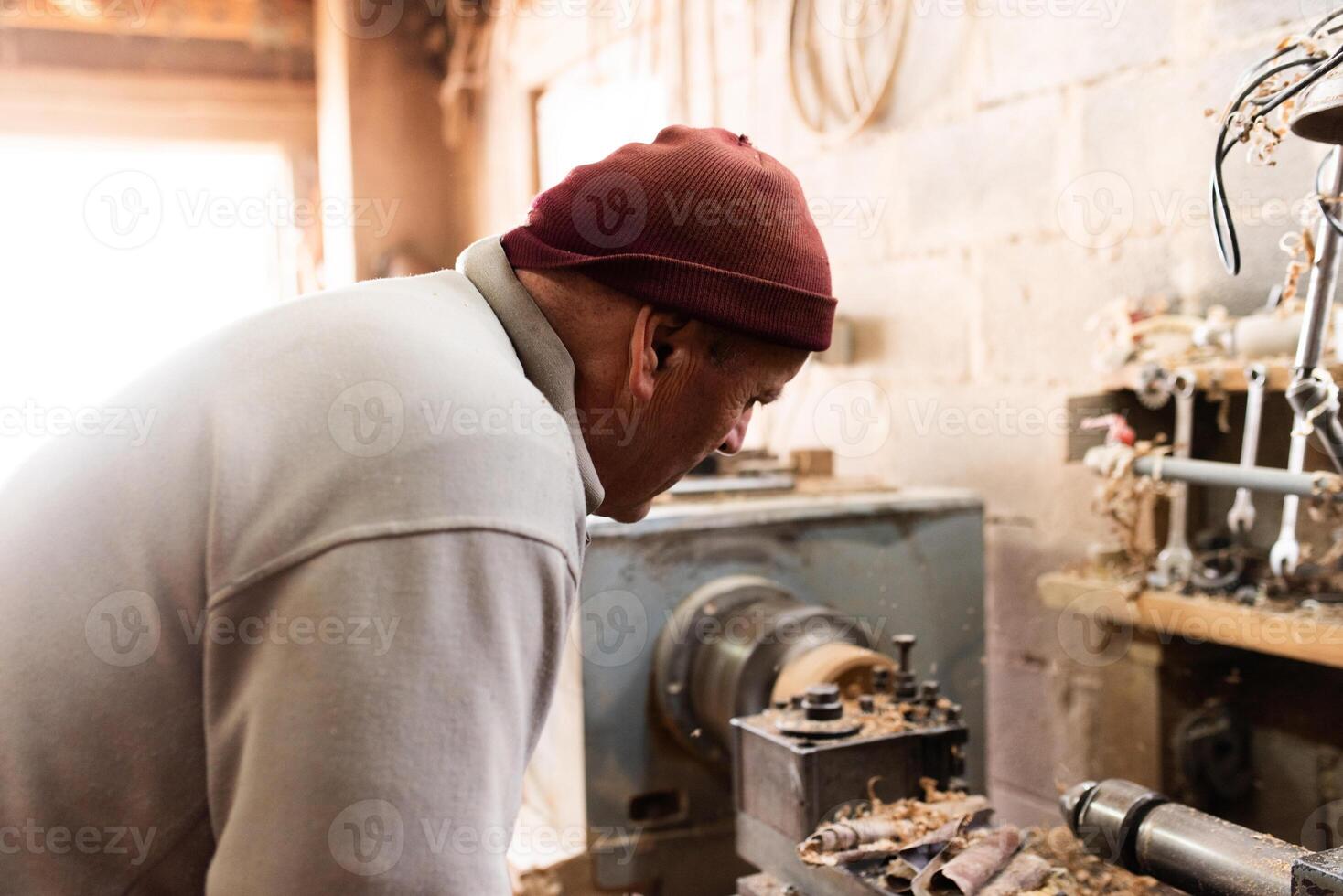 Elderly Craftsman Working in a Rustic Workshop photo