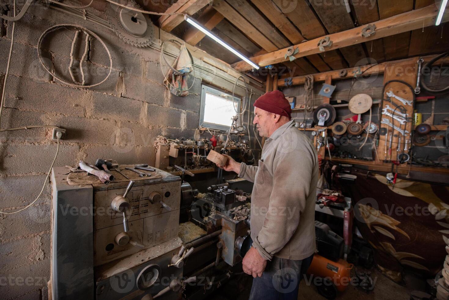 Elderly Craftsman Working in a Rustic Workshop photo
