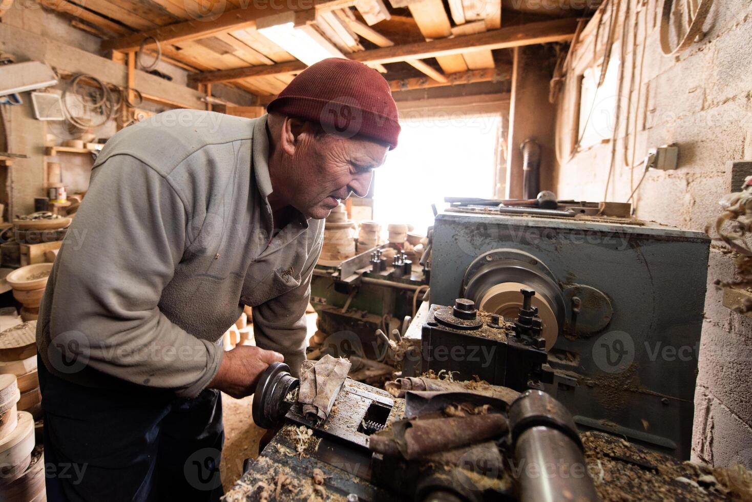 Elderly Craftsman Working in a Rustic Workshop photo