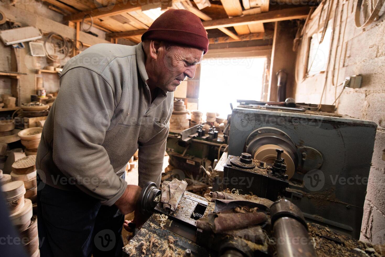 Elderly Craftsman Working in a Rustic Workshop photo