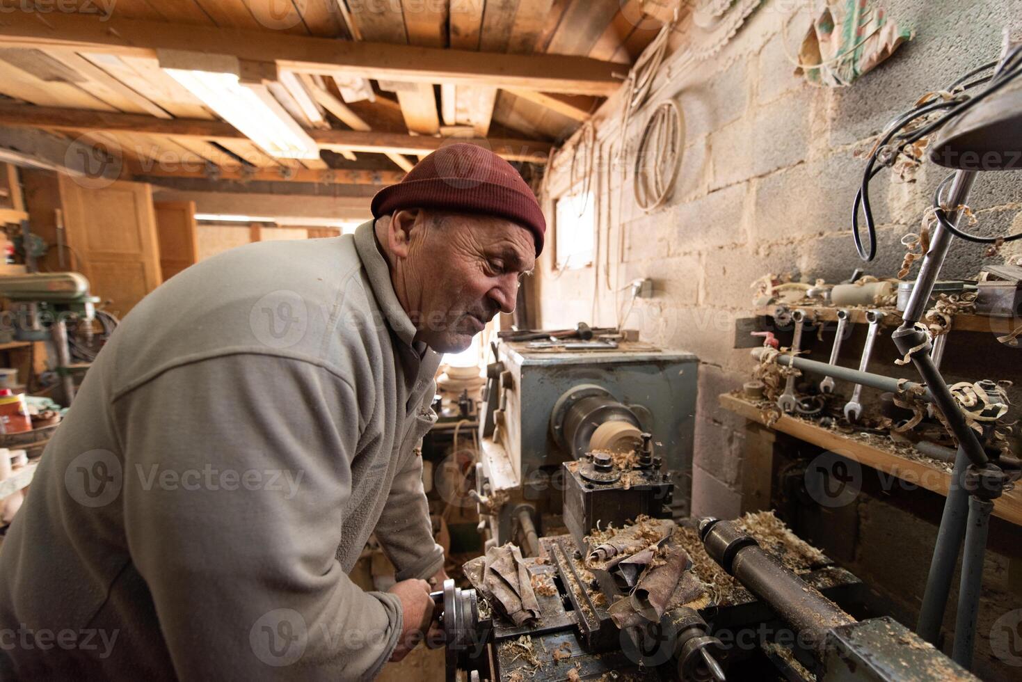 Elderly Craftsman Working in a Rustic Workshop photo
