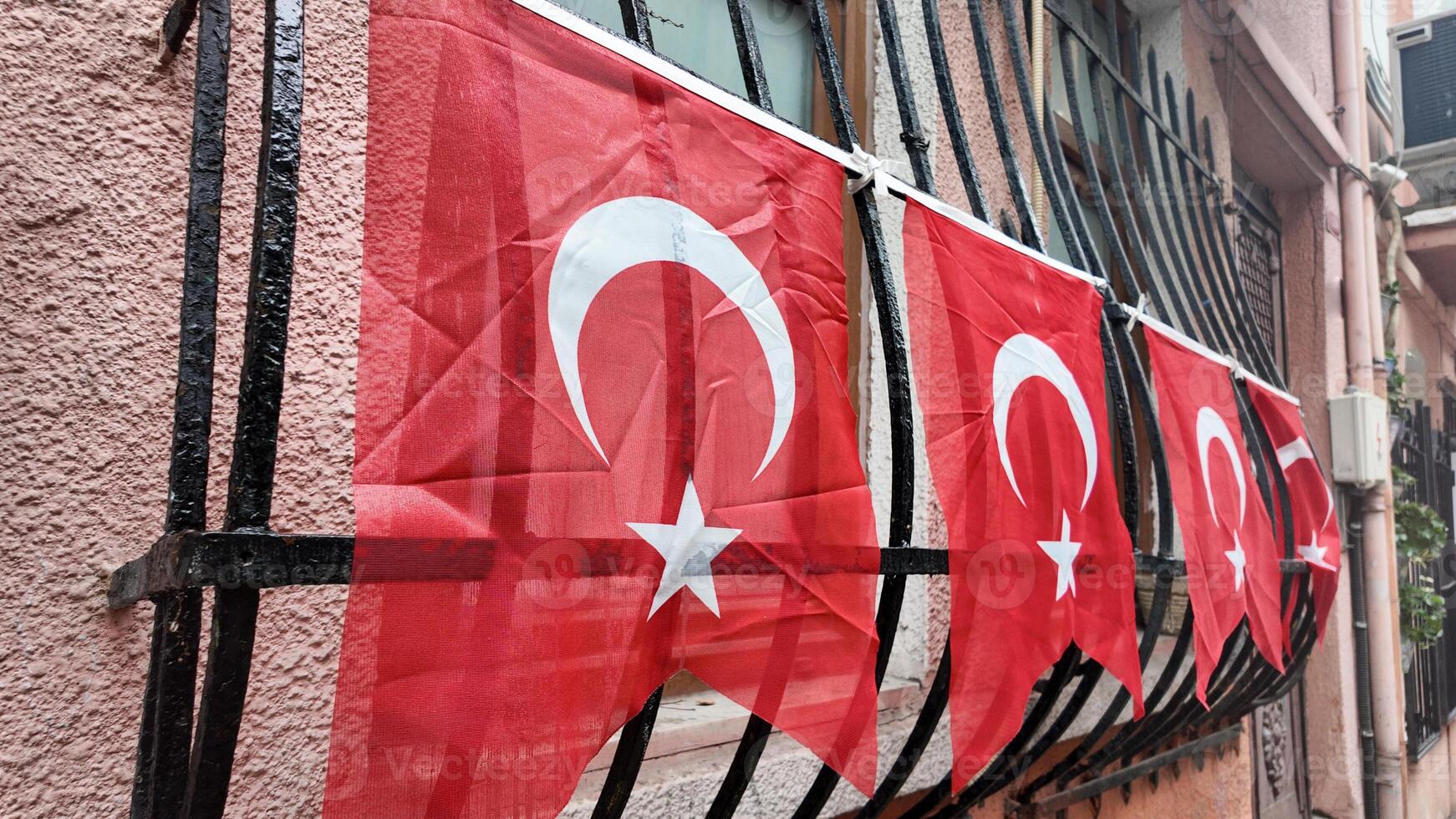 Turkish flags hang from balcony in urban neighborhood photo