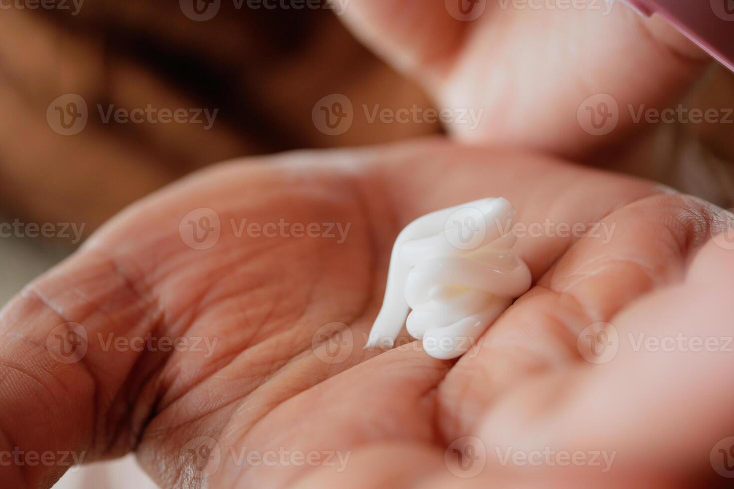 Applying moisturizing cream in a person's hand indoors photo